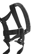 Black GENTLEBEAST dog headcollar displayed on a wooden surface, showcasing its adjustable strap and sturdy design.