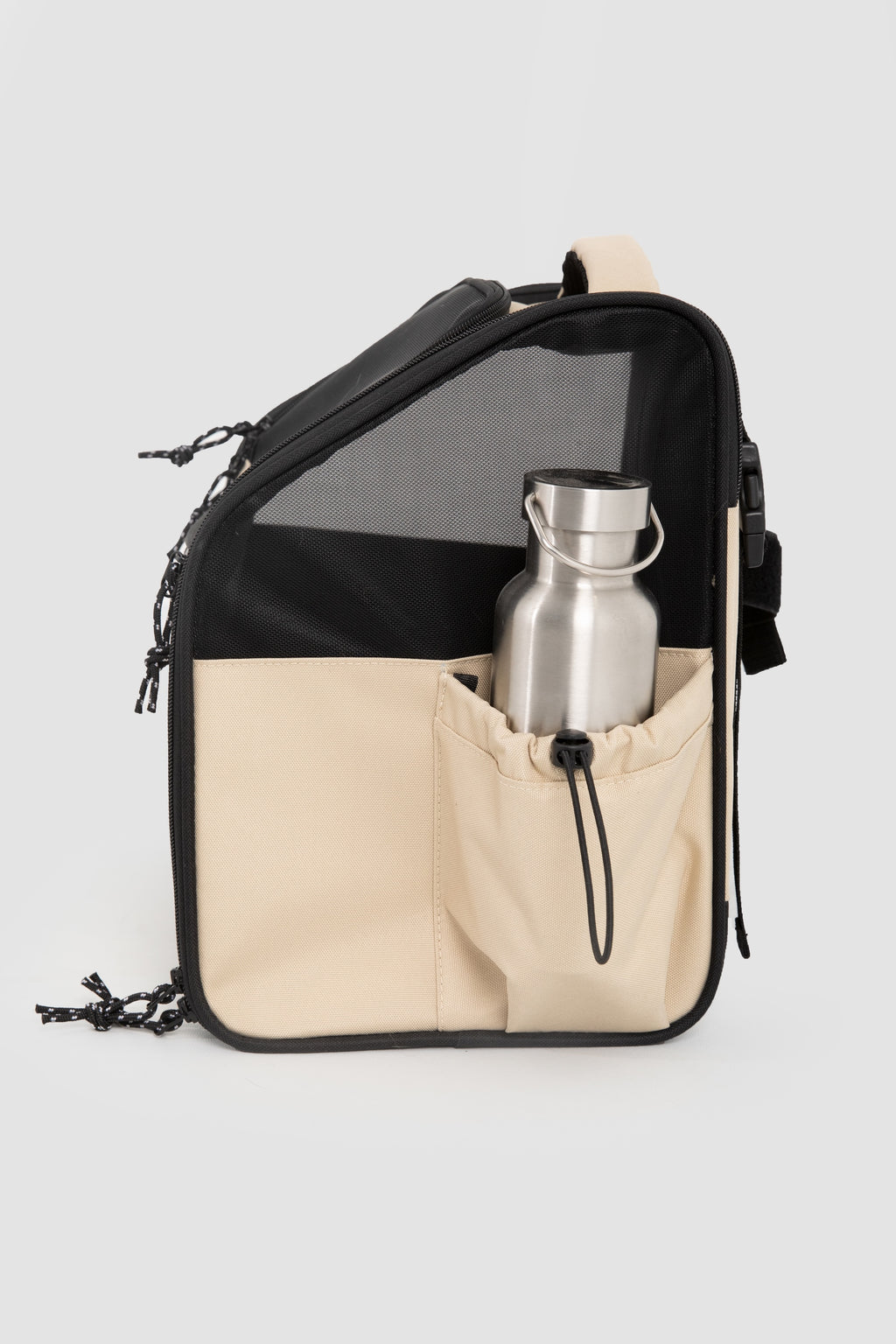Black and beige bag with a silver water bottle on a light gray background