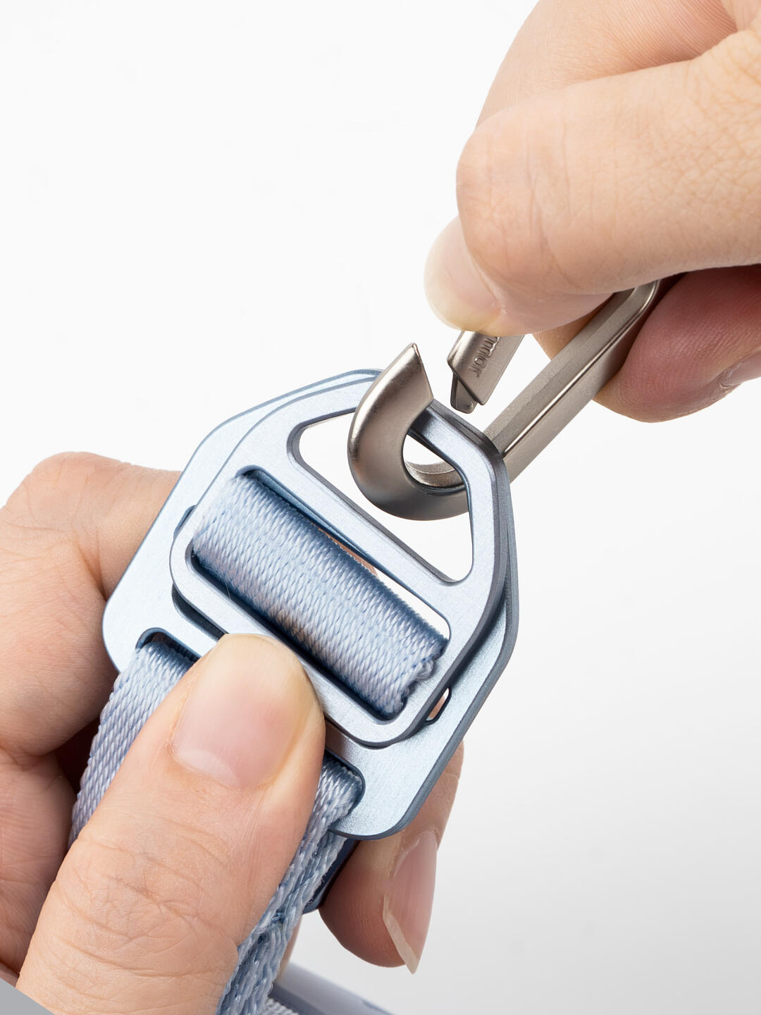 Close-up of a hand holding a buckle with a white background