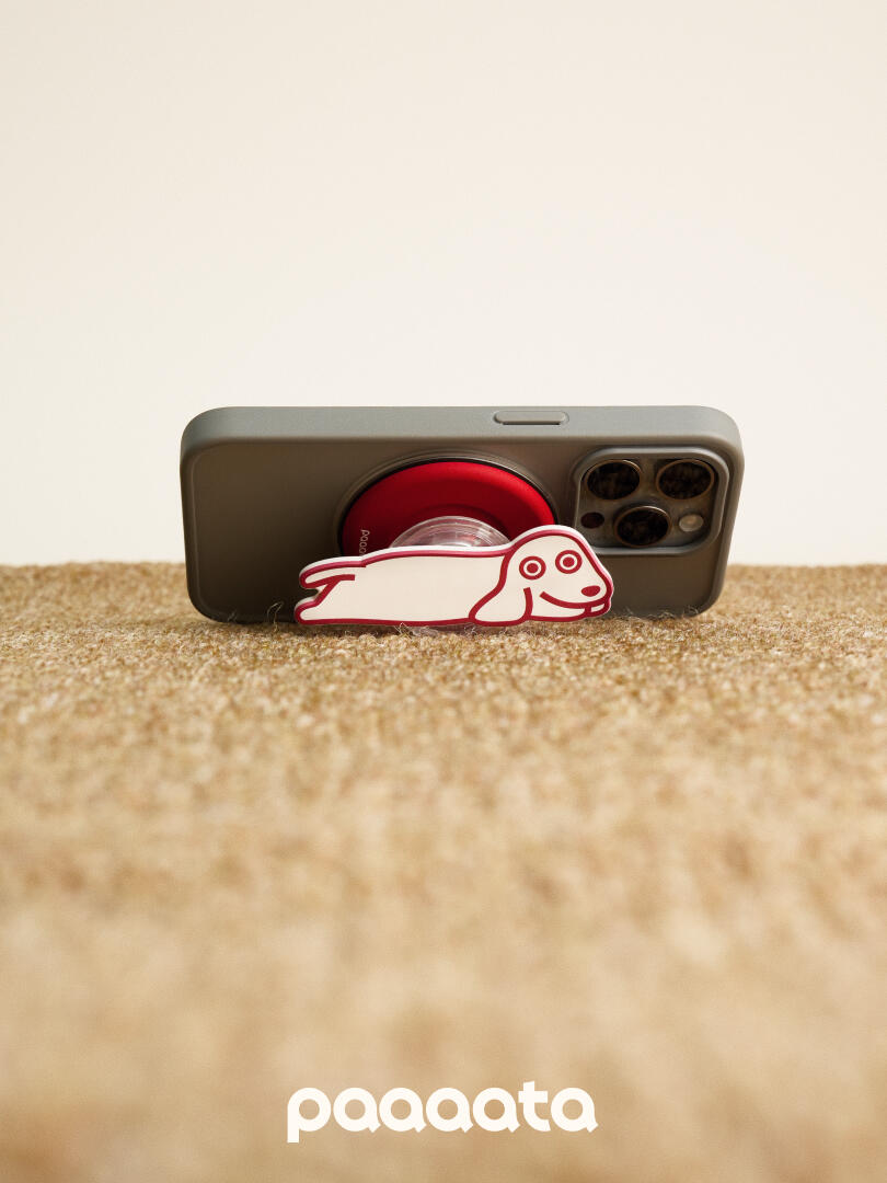 Phone case with a dog design on a beige surface, featuring the brand 'paaaata'.
