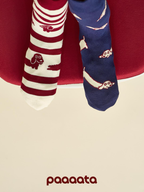 Two pairs of socks with animal patterns on a red chair.