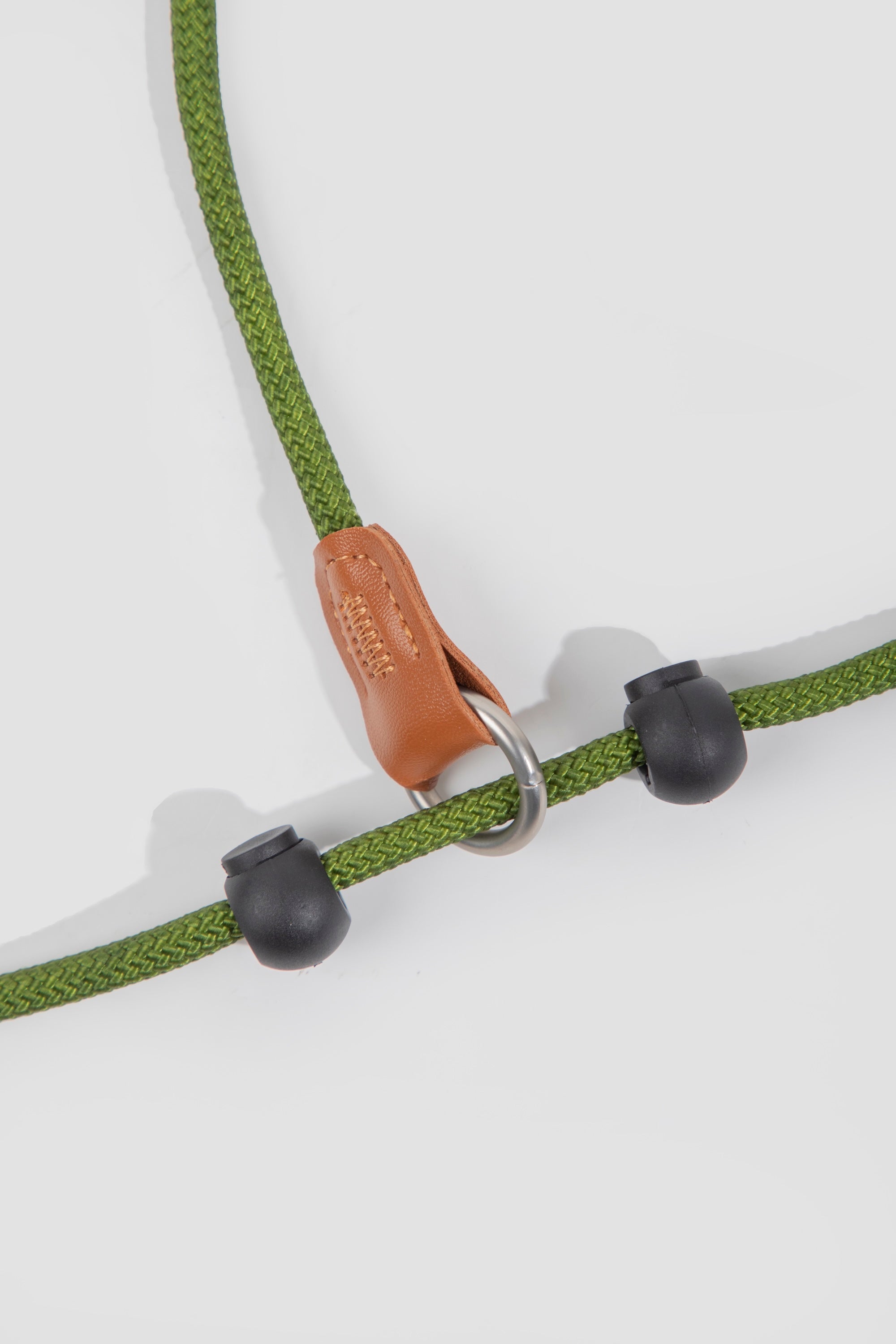 Close-up of adjustable stopper on a green nylon rope slip dog leash, showing sliding limiter that controls tightening.