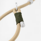 Detail view of braided binding and aluminum end cap on a beige rope dog leash, emphasizing craftsmanship and material finish.