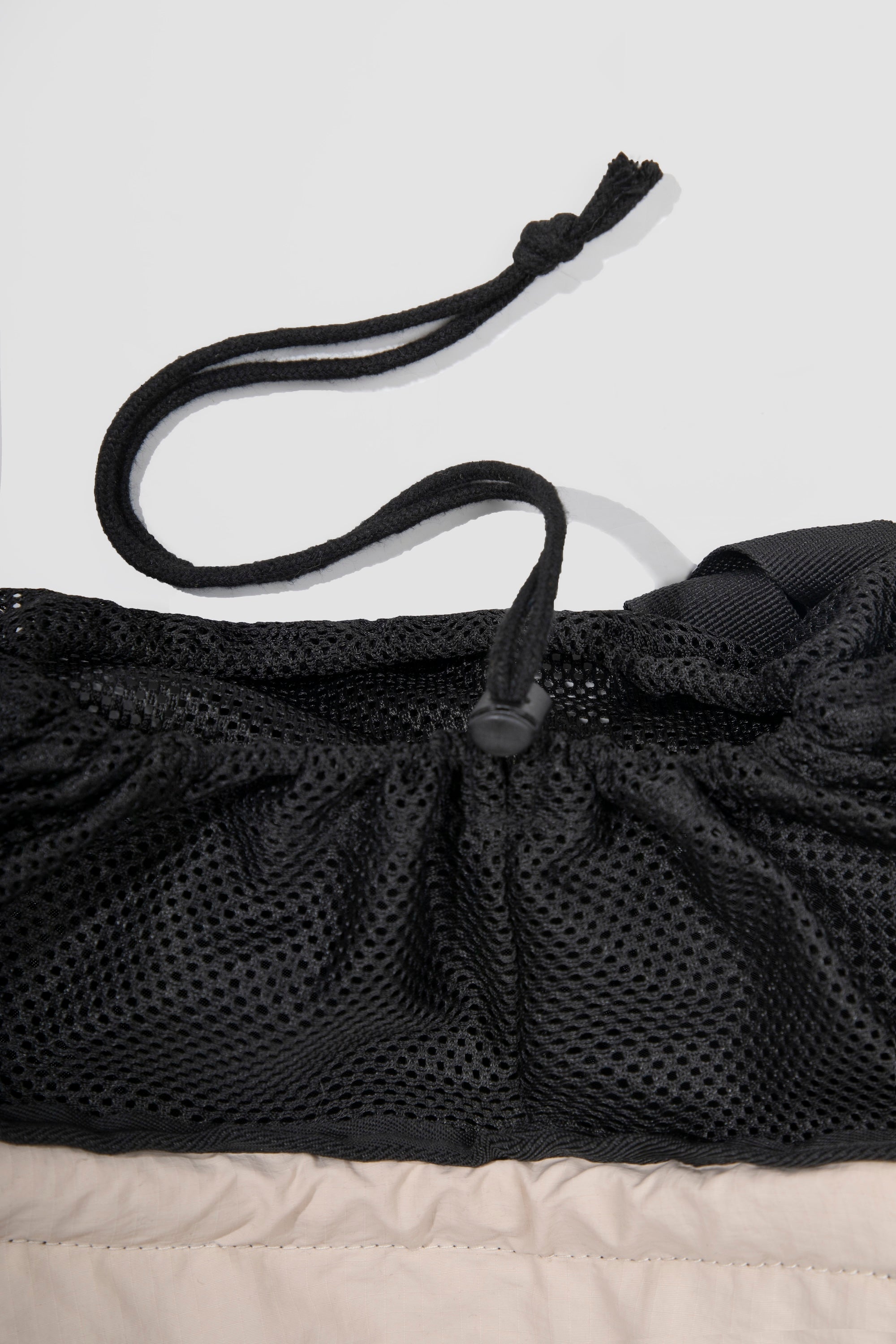 Detail of breathable mesh and drawstring system on a cat front carrier, allowing adjustable opening and secure fit