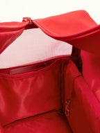 Interior view of a red pet carrier bag showing breathable mesh panel and structured inner space