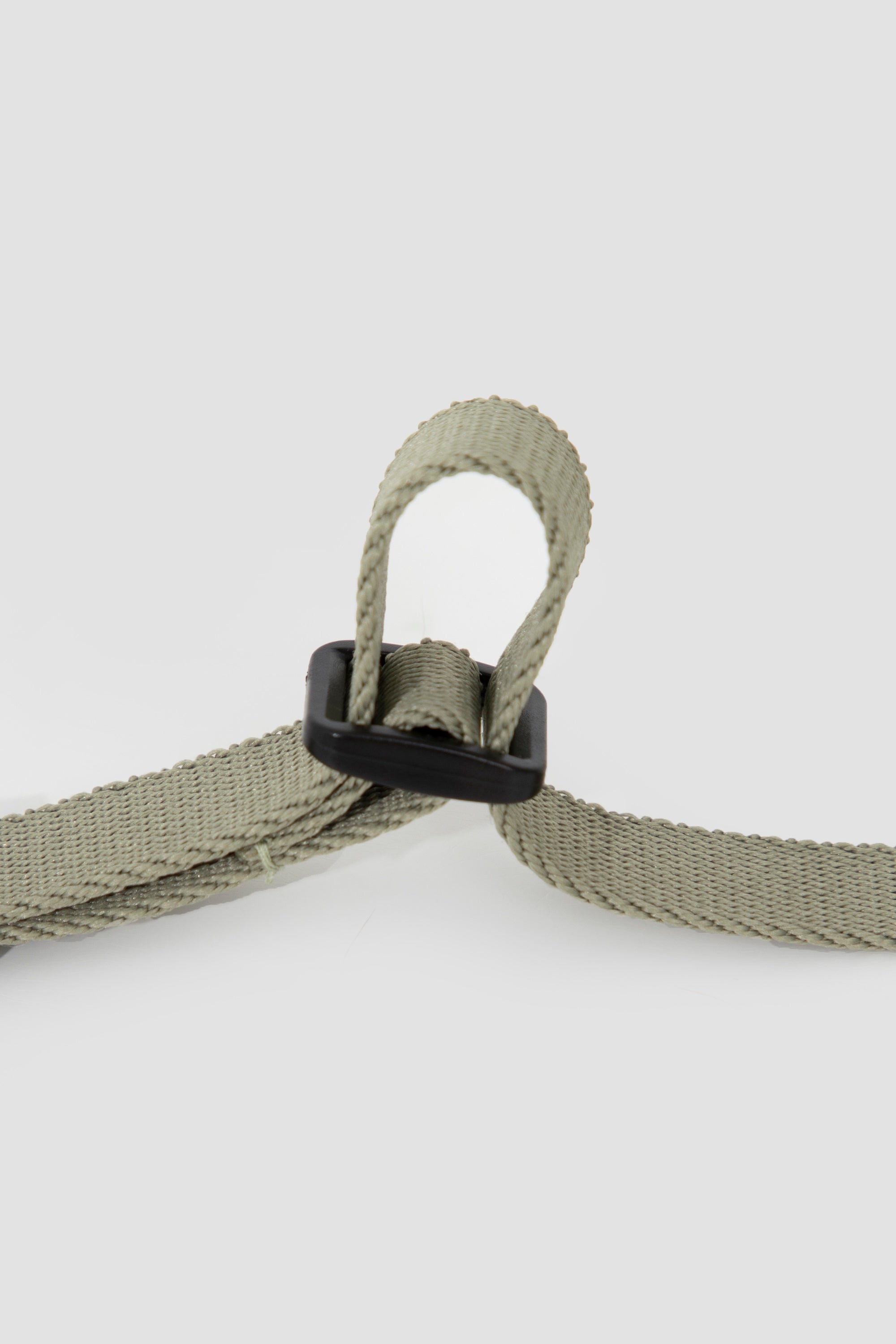 Detail of adjustable woven strap on the cat harness, featuring a plastic slider that allows precise size adjustment for a secure fit.