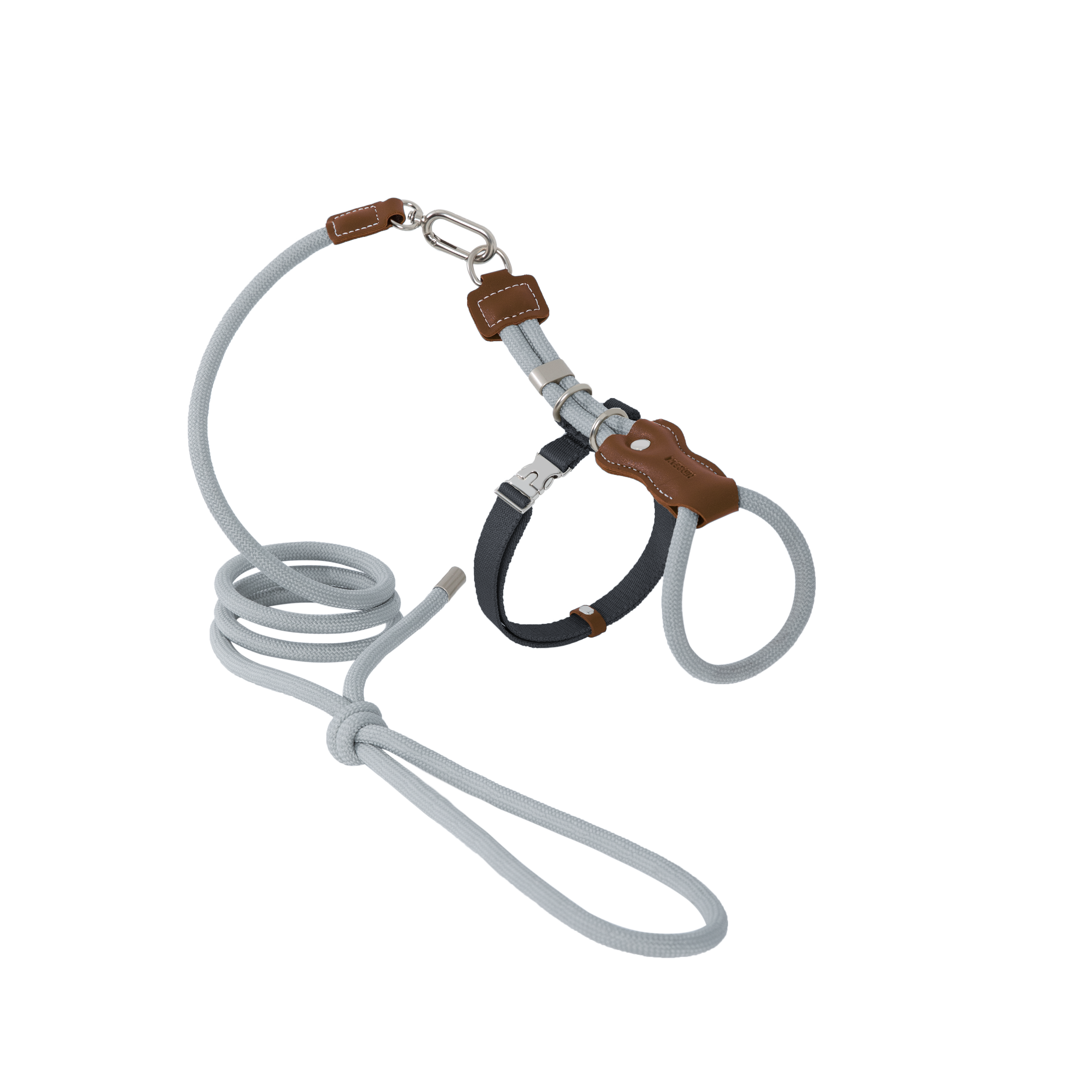 Flat lay of a cat harness and leash set with leather accents, showing the combination of braided rope, leather details, and metal hardware.