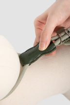 Close-up of the leather adjustment detail on a cat harness leash set, showing stitched leather and rope construction.
