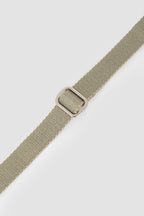 Close-up of the matte metal adjustment ring on a cat harness strap, showing smooth sliding and secure fit control.