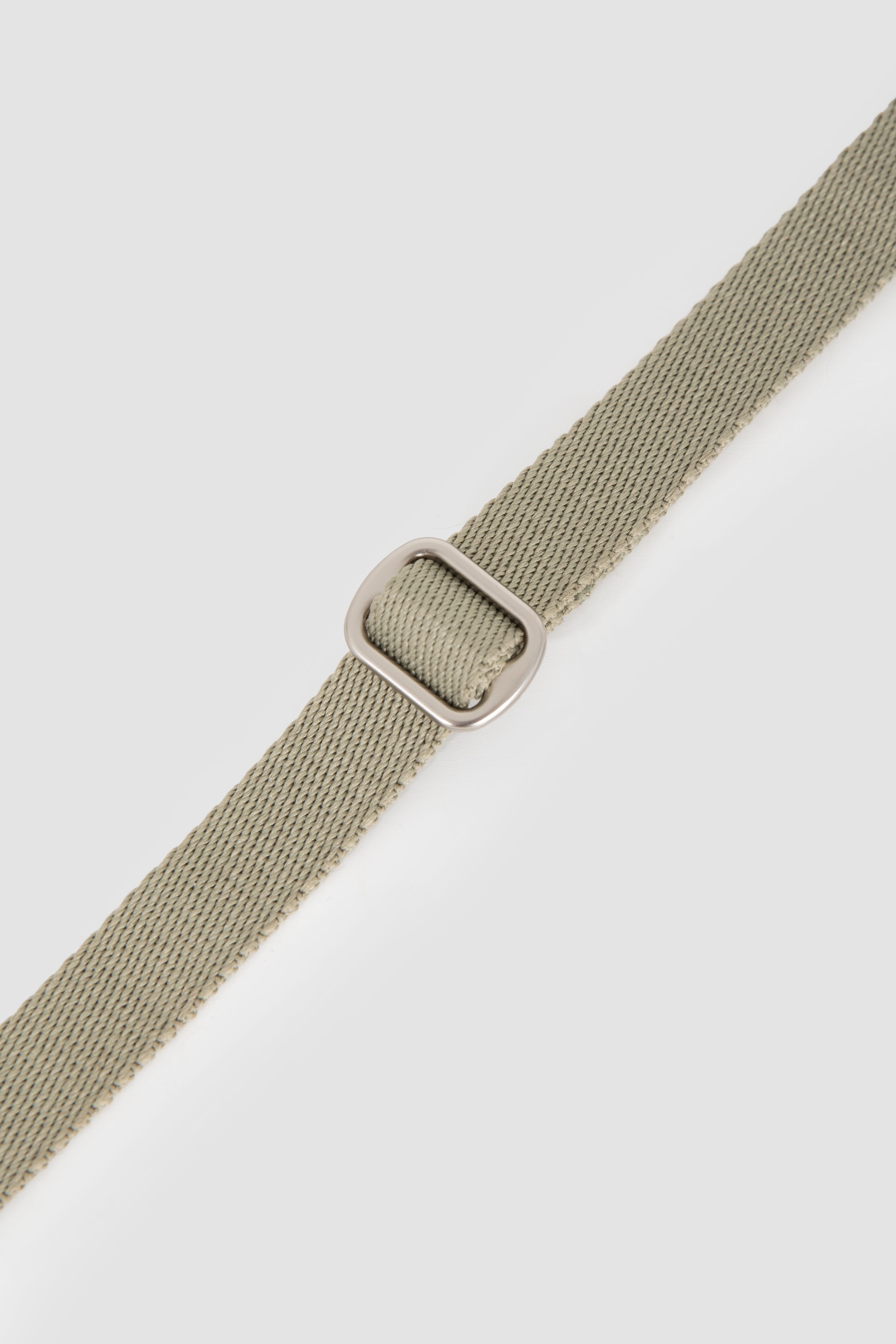 Close-up of the matte metal adjustment ring on a cat harness strap, showing smooth sliding and secure fit control.