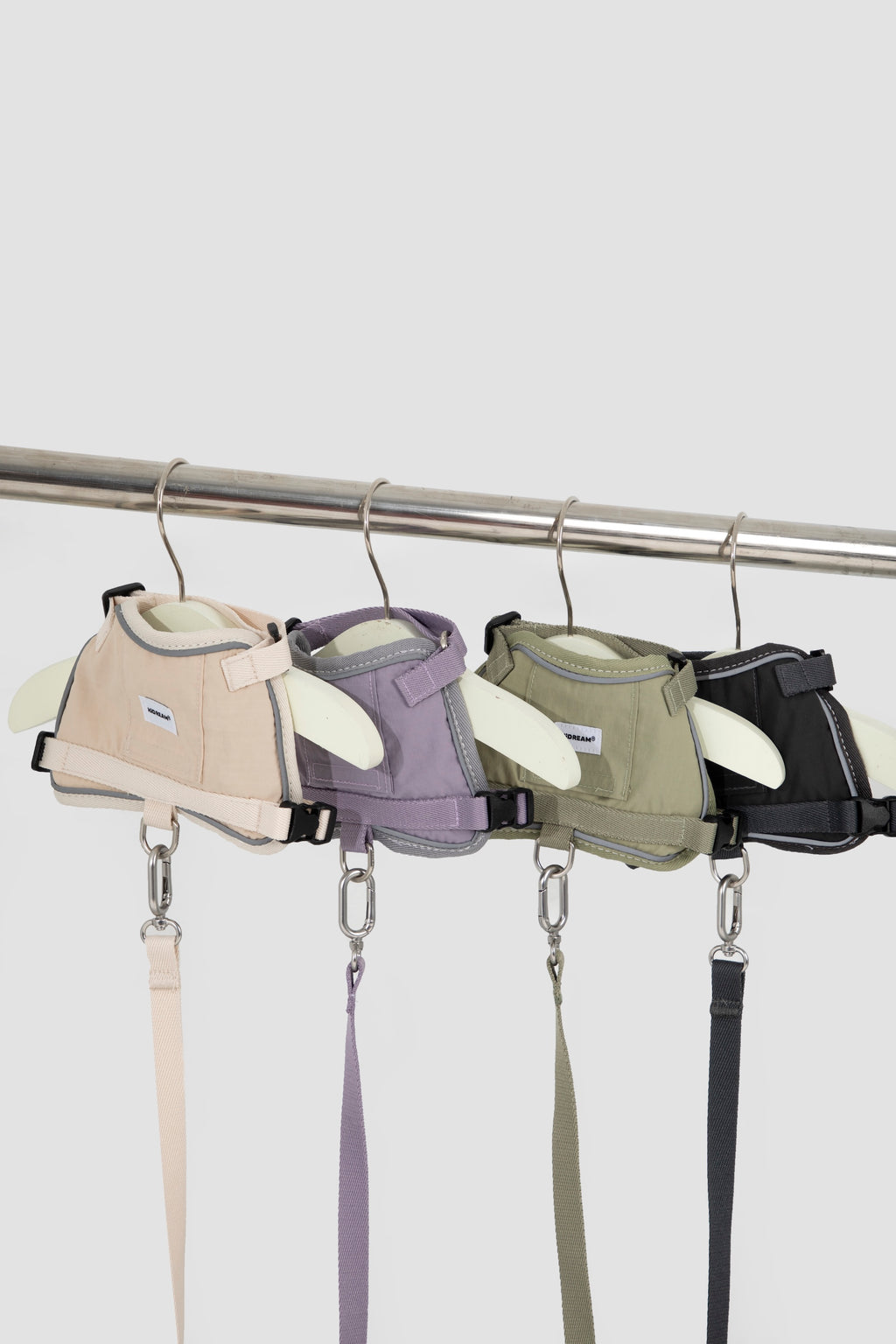 Cat collar harness set displayed on hangers in four colors—beige, purple, olive, and black—with matching leashes and metal clips shown for color comparison.
