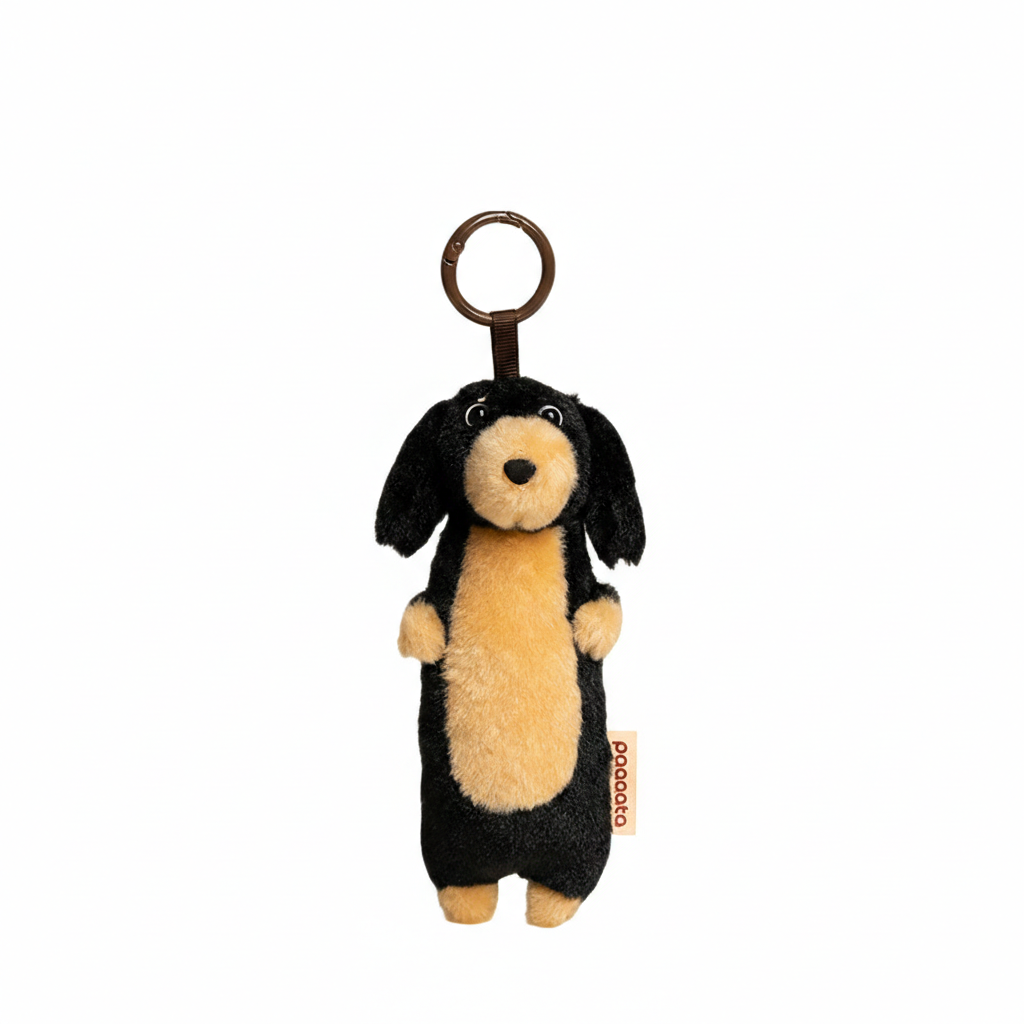 Black plush dachshund keychain with long hair from paaaata, featuring detailed dog-shaped design and attached keyring.