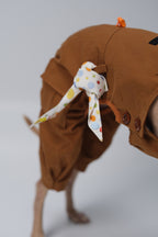 Polka dot cotton dog bandana tied as a decorative accent on the side of a brown dog overall