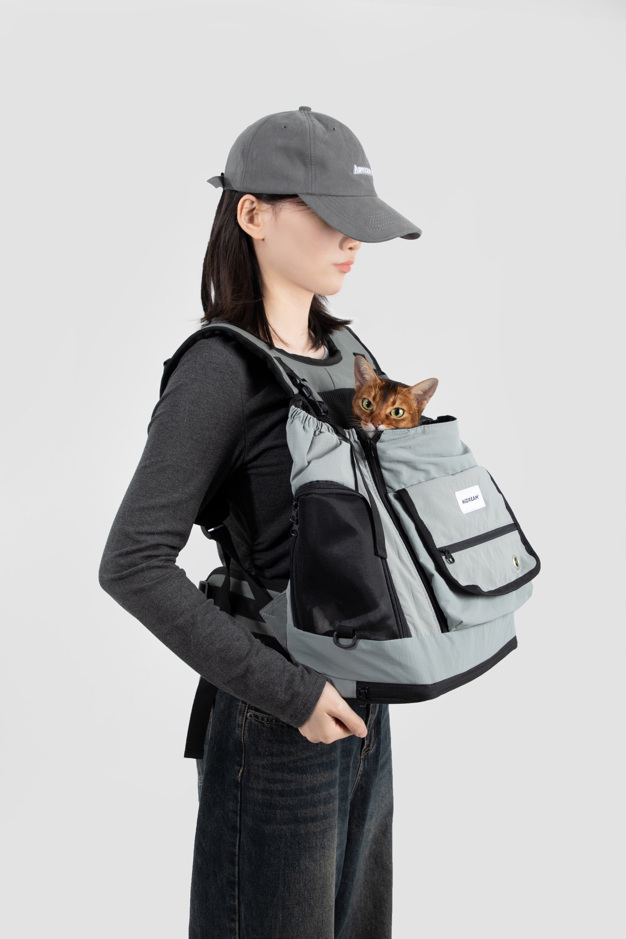 Side view of a dog front carrier bag worn on the body, showing adjustable shoulder straps and compact front-carry profile.