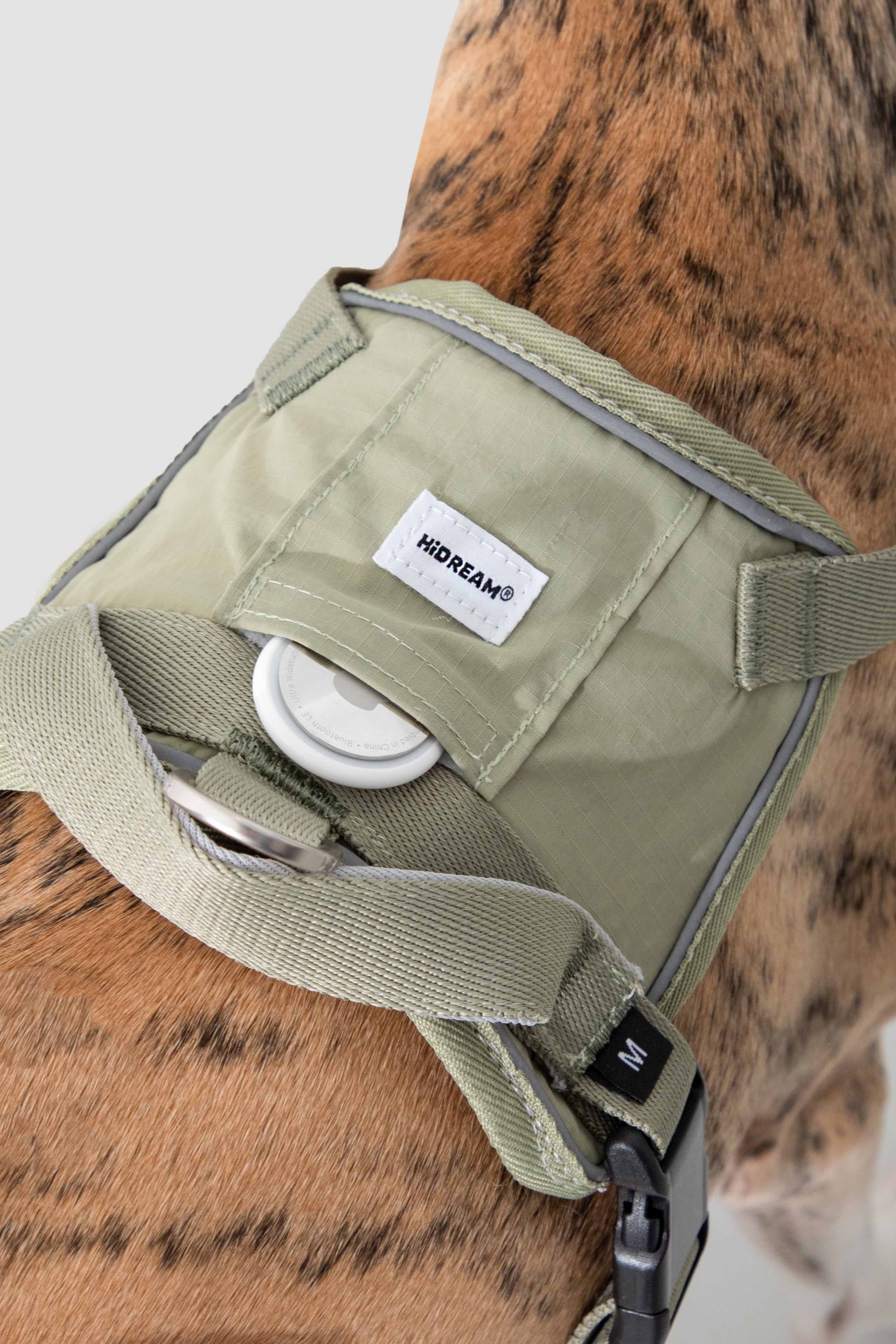  Close-up of the dog harness top handle and hidden tracker pocket area, showing the carry handle, reflective trim, and pocket opening for a pet tracker.