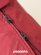 Close-up of dual YKK zippers on a red waterproof dog rain jacket, designed for smooth wear and easy access when using a harness.