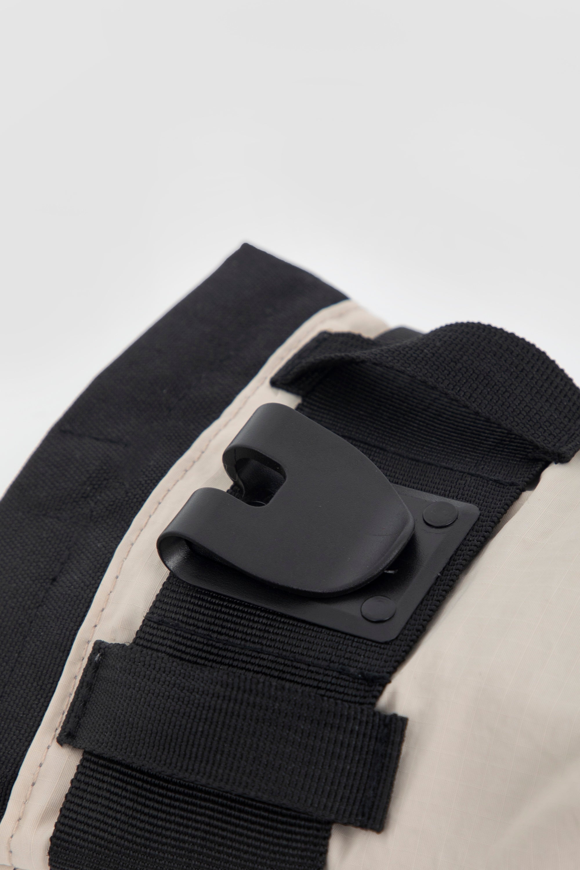 Close-up of the belt clip on the dog treat pouch, showing the clip hardware and webbing loops for attaching the pouch securely to a waistband or belt.