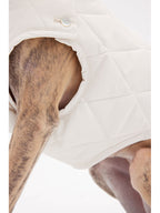 Close-up of the armhole opening on a quilted white dog vest, showing smooth edges and fit