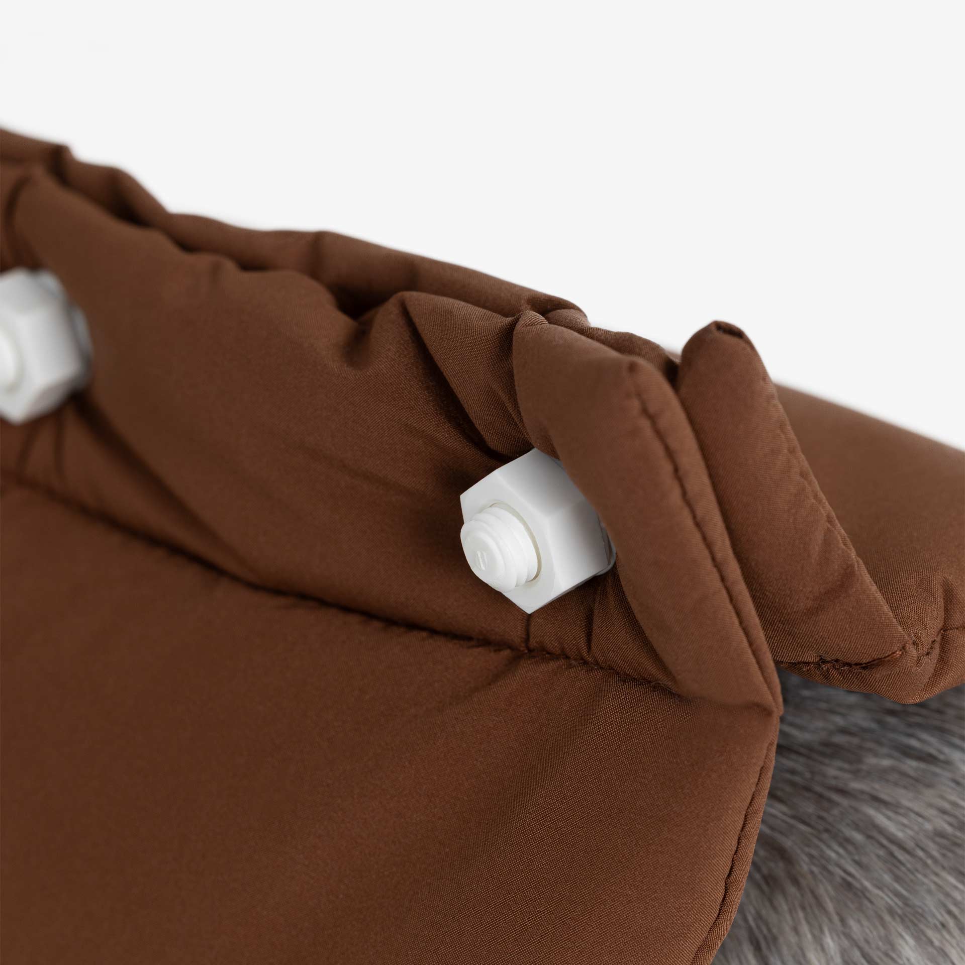 Close-up of the removable decorative bolt system on a padded dog vest, combining functional fastening with a clean finish.