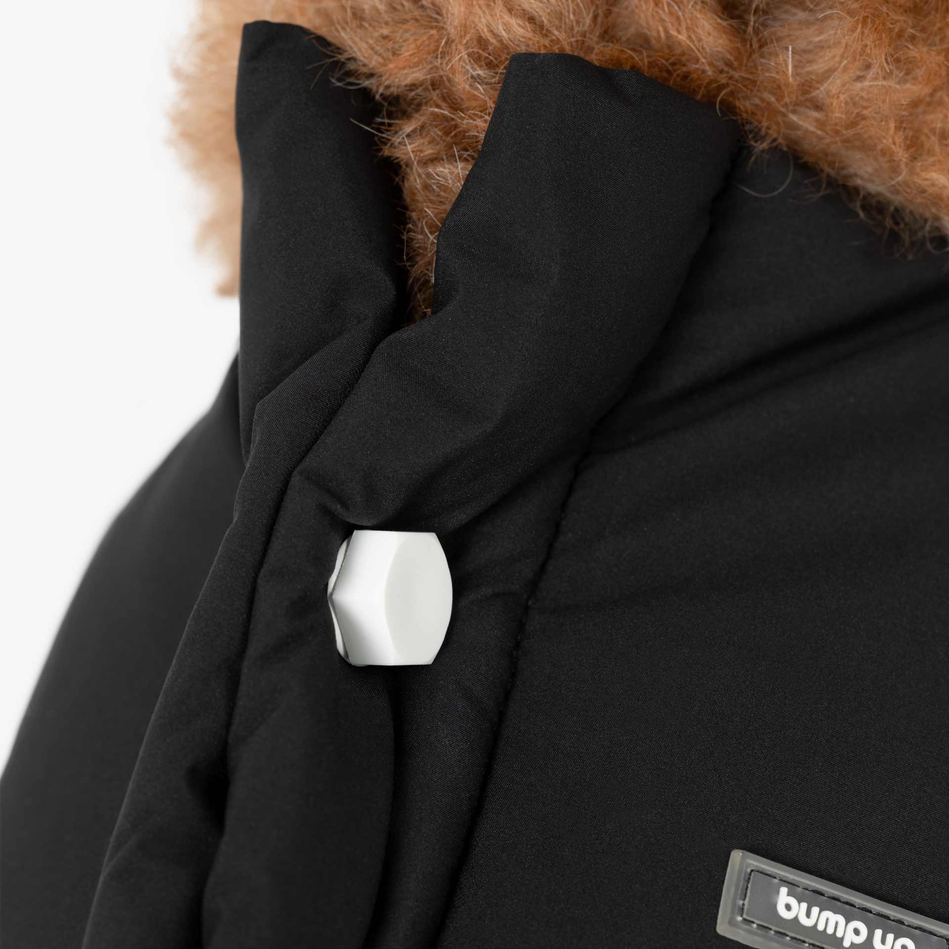 Close-up of removable decorative bolts on the back of a padded dog vest, combining functional fastening with minimalist design.