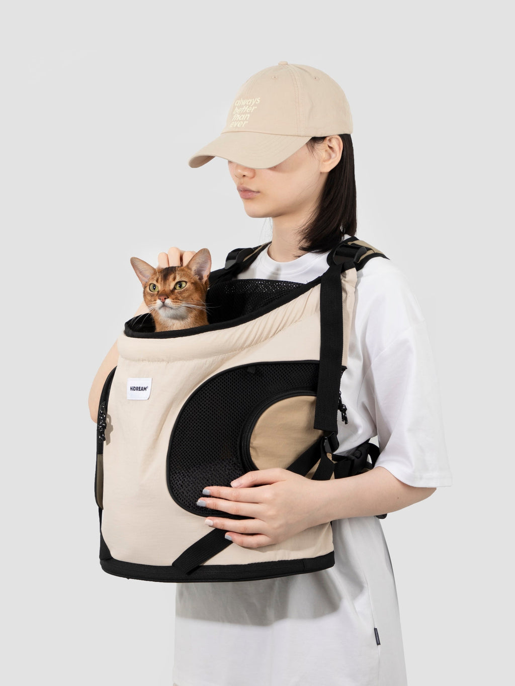 Model wearing an ergonomic front-facing cat carrier with spine-support design, breathable mesh panels, and structured bottom for daily pet travel