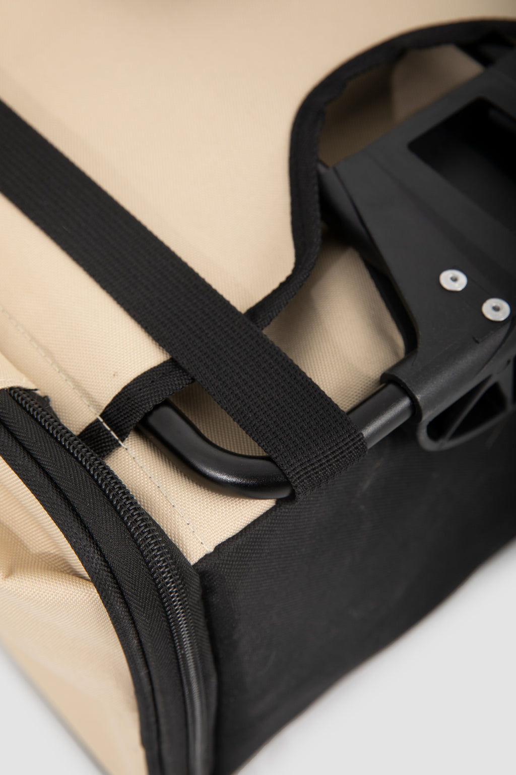  Close-up of the front bicycle pet carrier mounting area, showing a webbing strap secured around the support rack/frame for stable bike attachment.