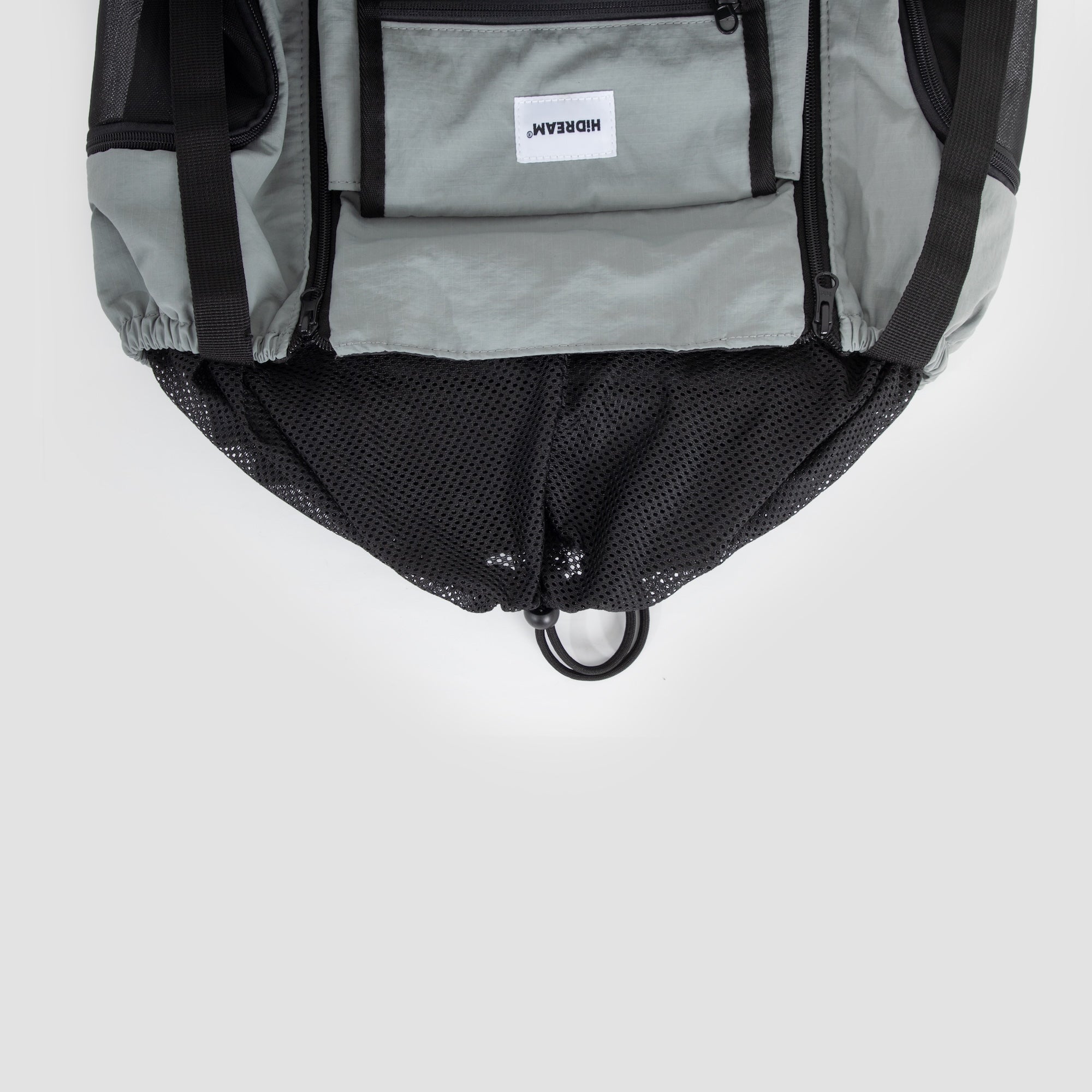 Bottom view of a front pet carrier with the mesh panel tightened using the drawstring for secure fit.