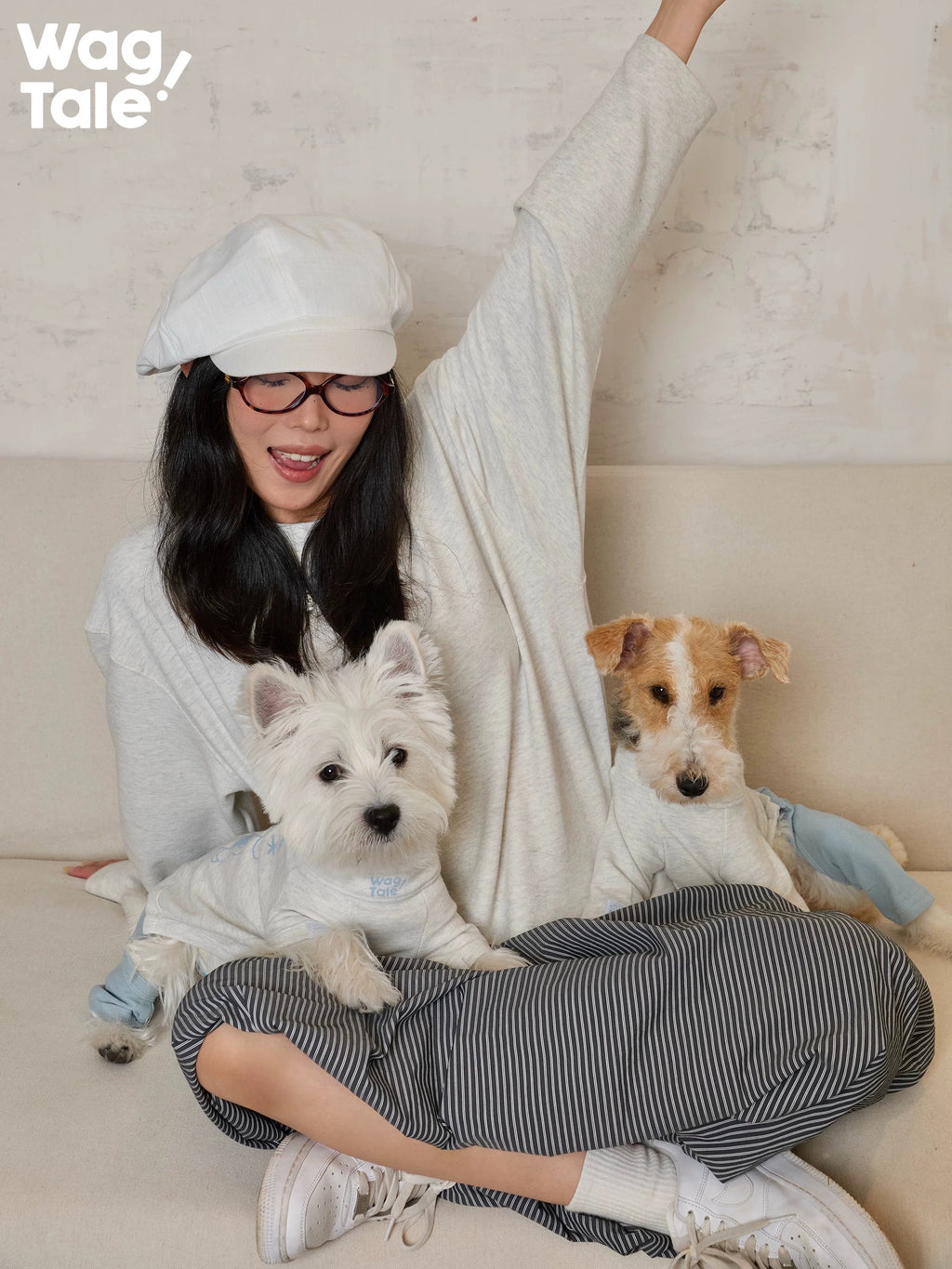 A person interacting with two dogs wearing graphic dog jumpers, highlighting playful mood and everyday wear styling.