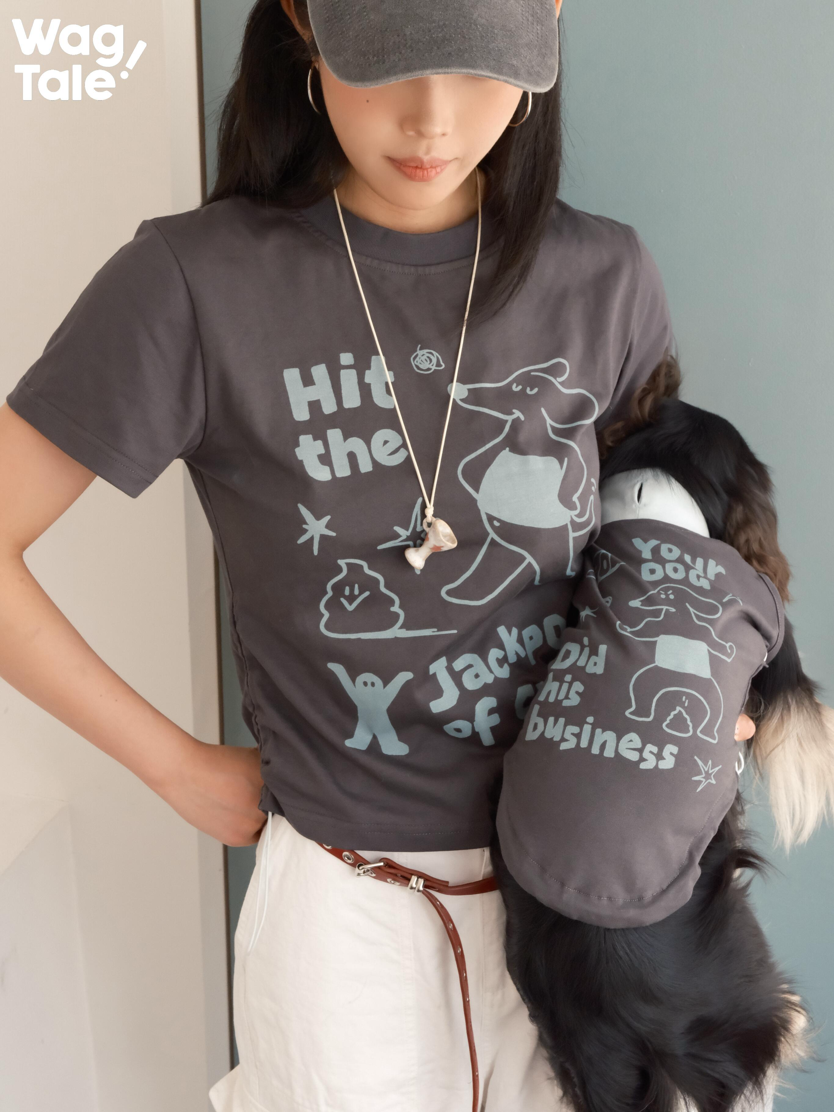 Close-up view of a graphic cotton T-shirt worn alongside a dog in a matching dog jumper, highlighting illustrated print details across human and dog outfits.
