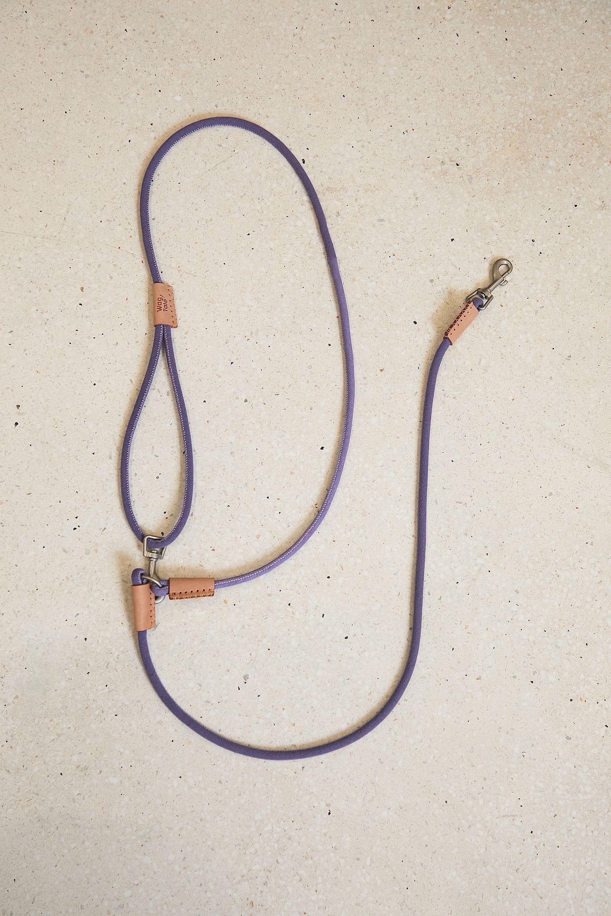 Hands-free crossbody dog leash in purple shown in a flat lay view, highlighting adjustable hardware, lightweight rope body, and everyday walking design.