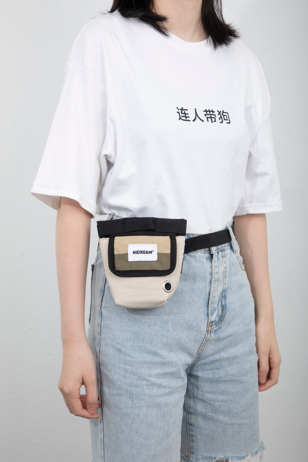 Side-angle view of a hands-free dog treat pouch worn on a waist belt, highlighting how the pouch sits against the body during walks.