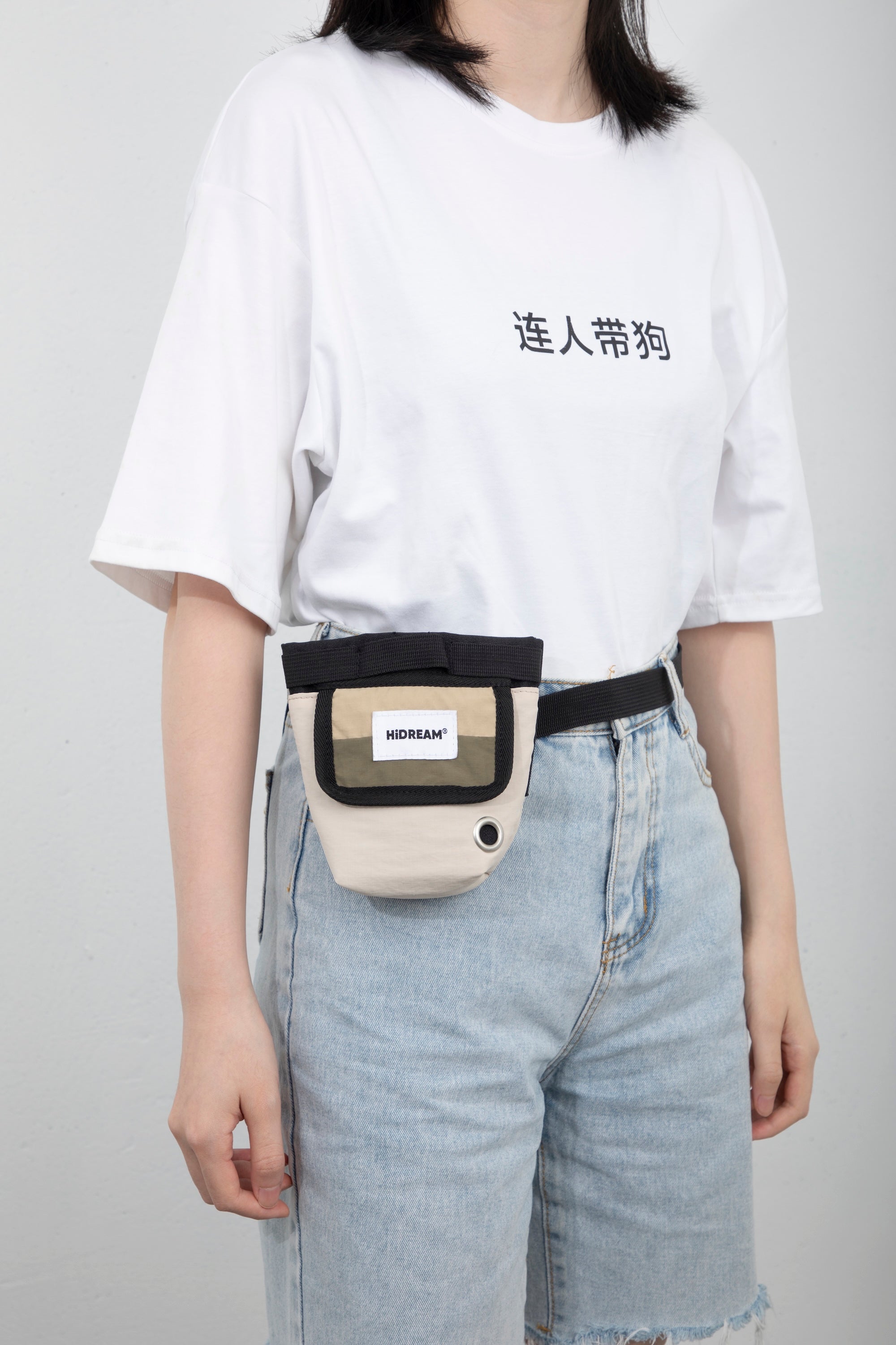 Side-angle view of a hands-free dog treat pouch worn on a waist belt, highlighting how the pouch sits against the body during walks.