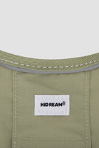 Close-up of the Hidream label stitched on a green cat harness, clearly showing the harness fabric texture and material detail.