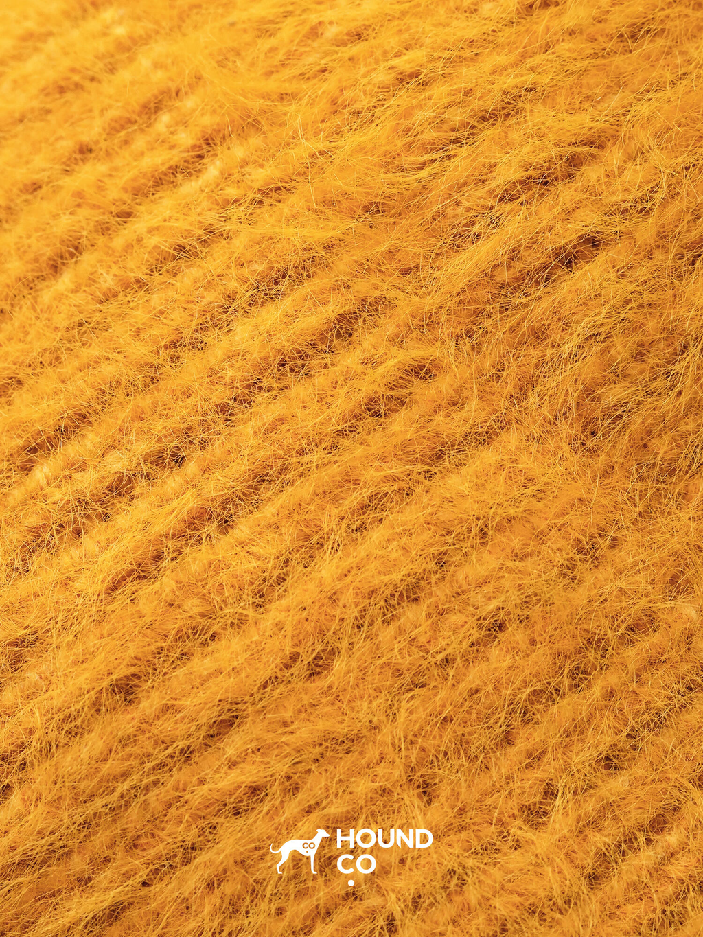 Close-up of Hound Co.'s mustard yellow fuzzy knit fabric, showcasing its soft, plush texture ideal for cozy winter dog accessories.