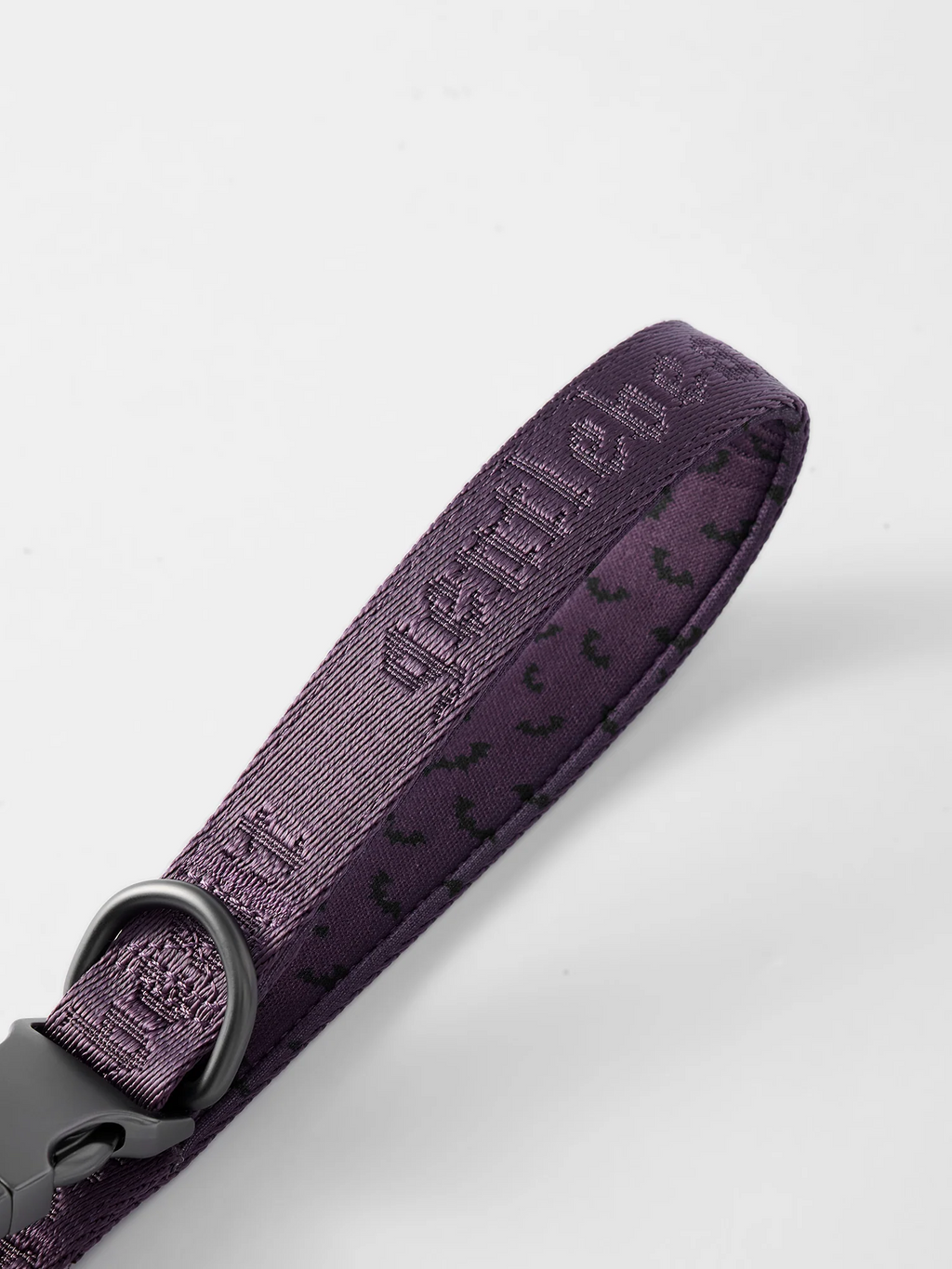 Purple GENTLEBEAST dog leash displayed on a wooden surface with a metal clip and soft grip handle visible.