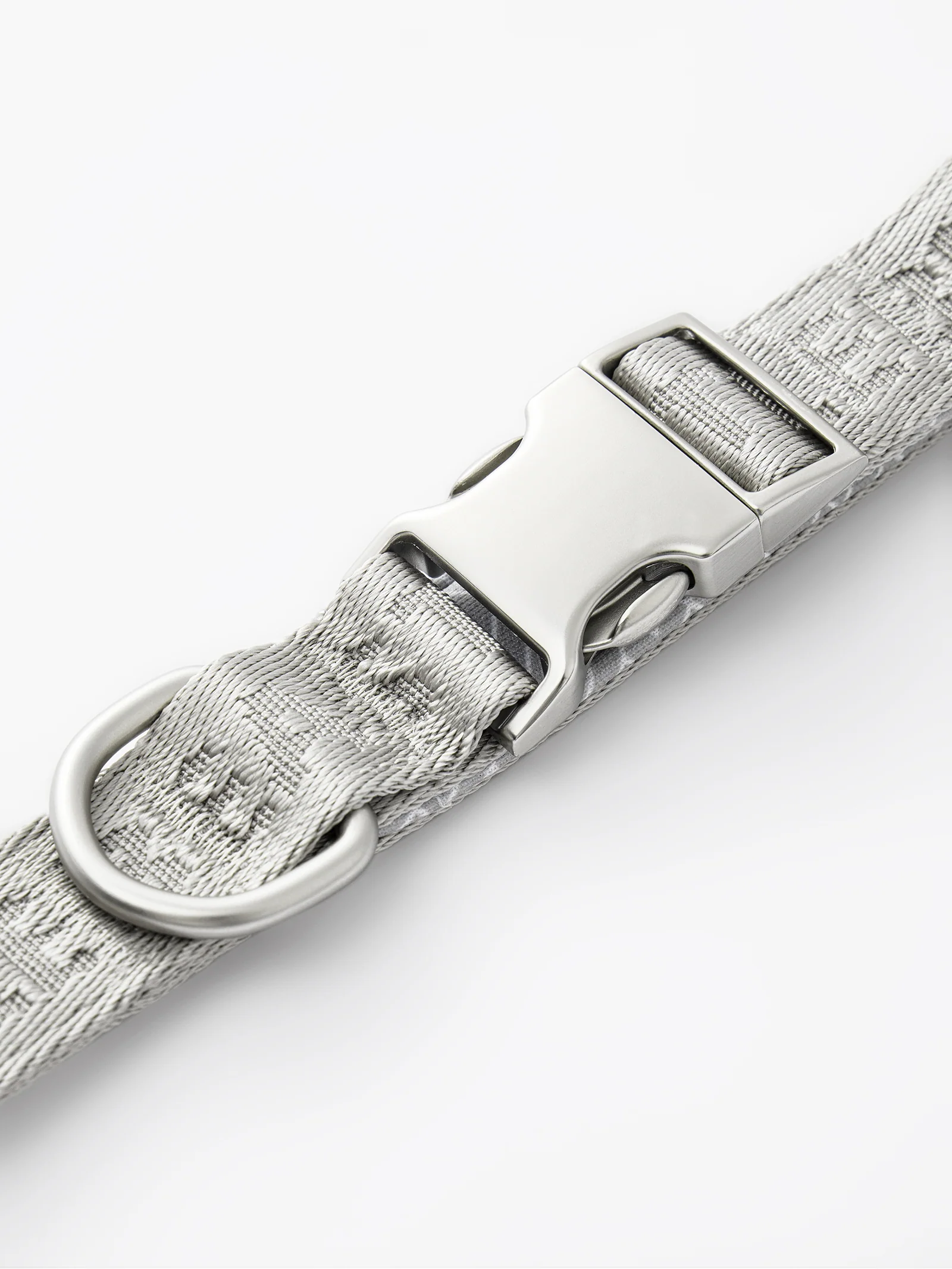 GENTLEBEAST silver dog short leash displayed on a textured surface, showcasing its sturdy design and clip.