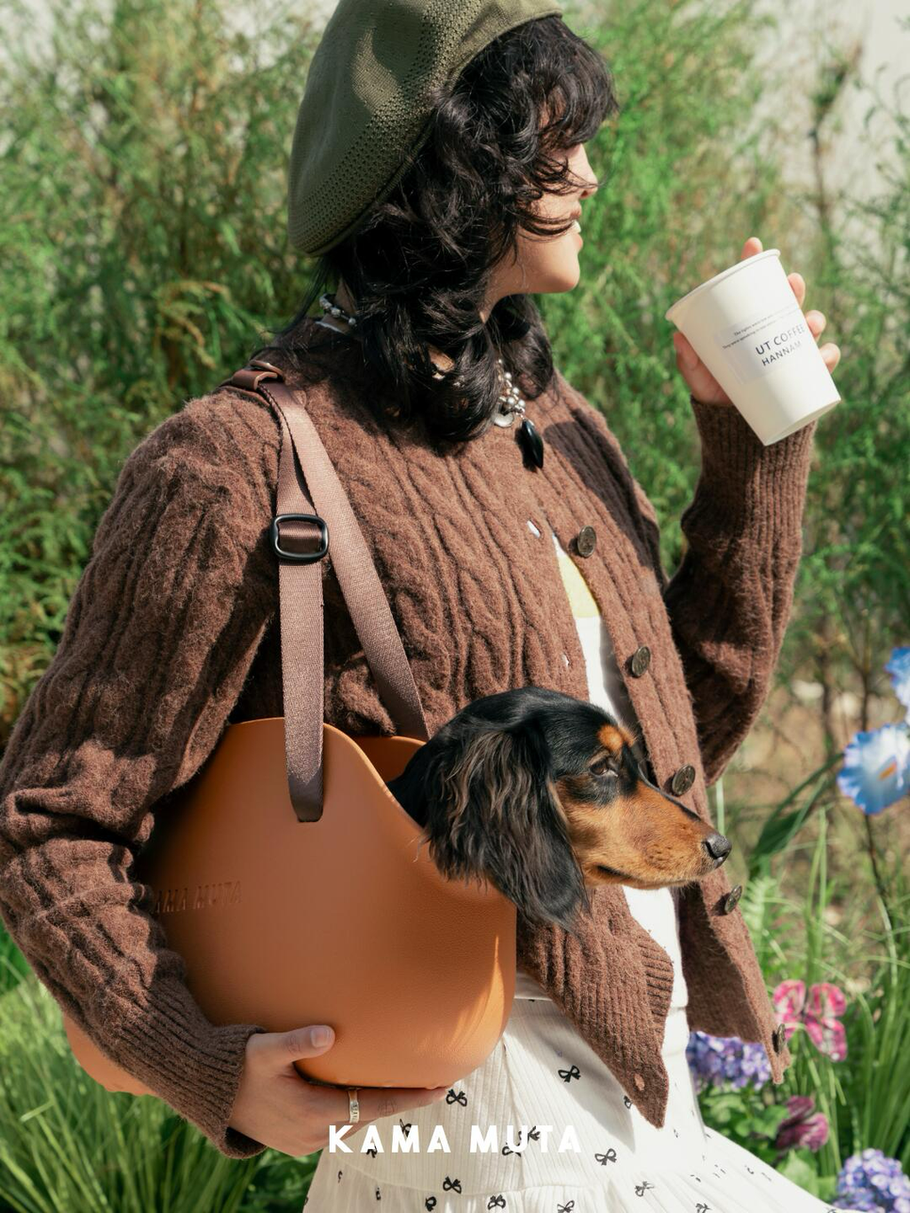 Dog tote carrier worn over the shoulder for outdoor travel, featuring adjustable strap and stable structure.