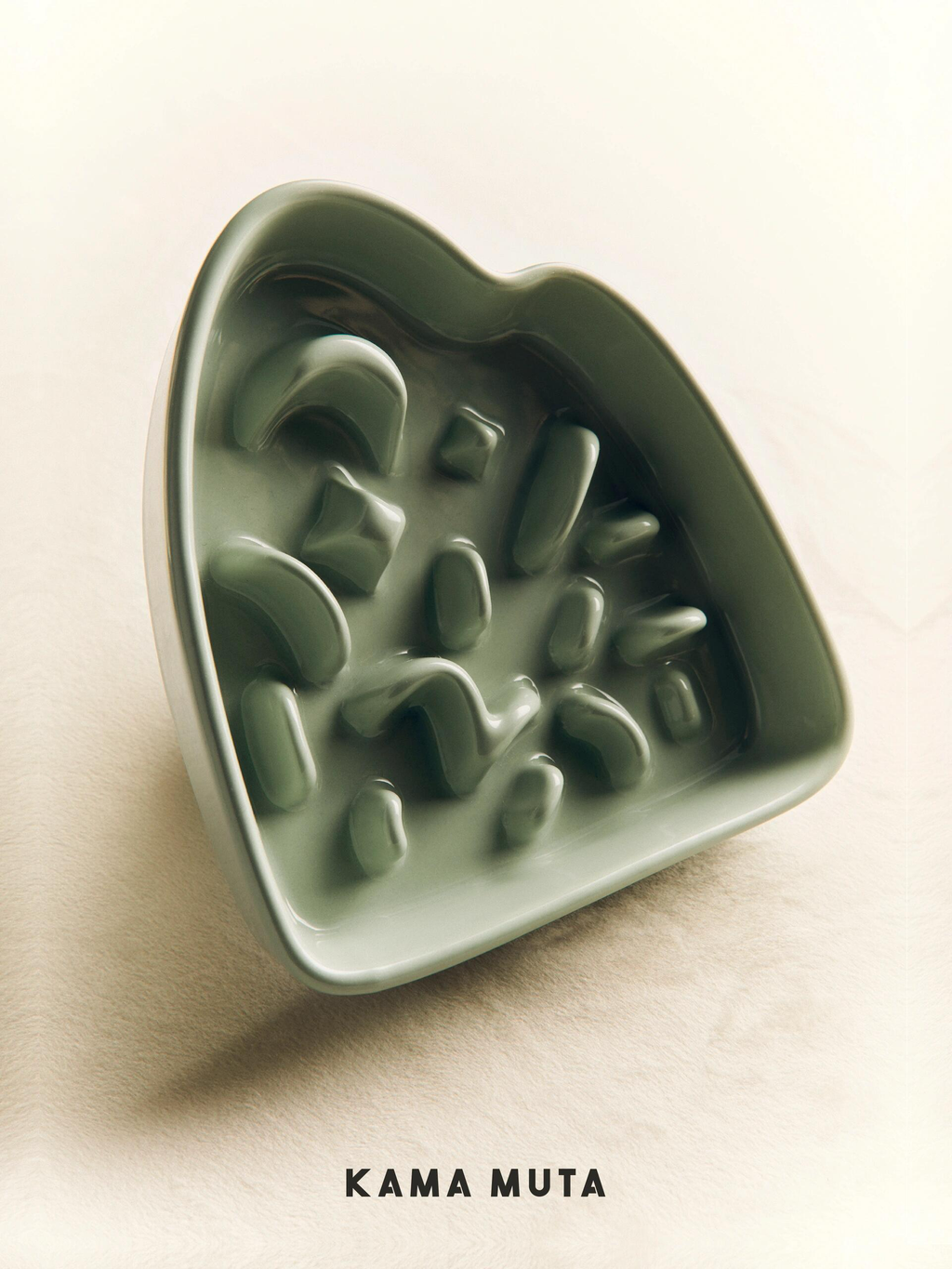 Light green heart-shaped ceramic slow feeder bowl for dogs (KAMA MUTA brand) with raised maze patterns
