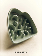 Light green heart-shaped ceramic slow feeder bowl for dogs (KAMA MUTA brand) with raised maze patterns