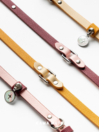 Leather dog leash flat lay showcasing multiple color options and refined litchi grain texture with minimalist metal details
