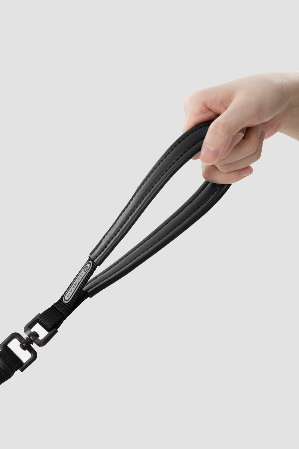 Hand holding the padded leather handle of a slip dog leash, showing comfortable grip for dog training and daily walks.
