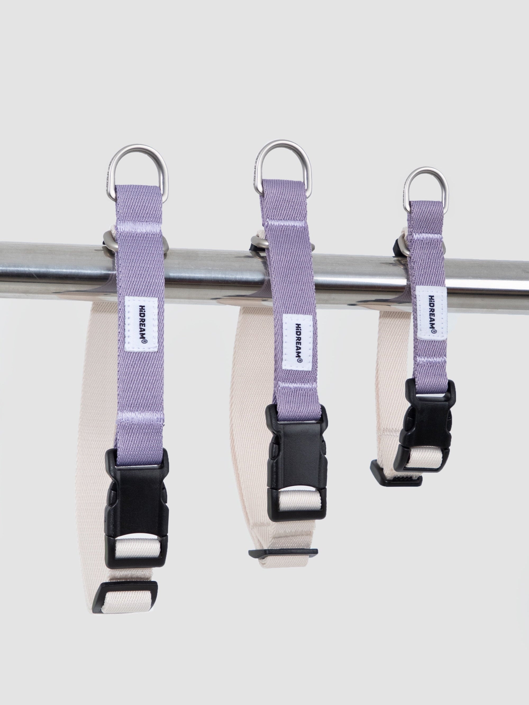 Three sizes of a martingale dog collar displayed side by side, showing adjustable webbing, D-rings, and anti-pull training structure.