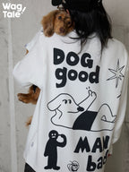 Back view of a person wearing a graphic sweatshirt while holding a dog in a matching dog jumper, showing bold illustration print and coordinated human and dog styling.