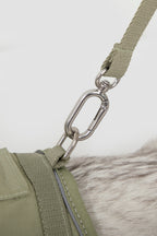 Close-up of metal leash clip attached to the cat harness D-ring, showing secure hardware connection for a cat collar harness set with leash.