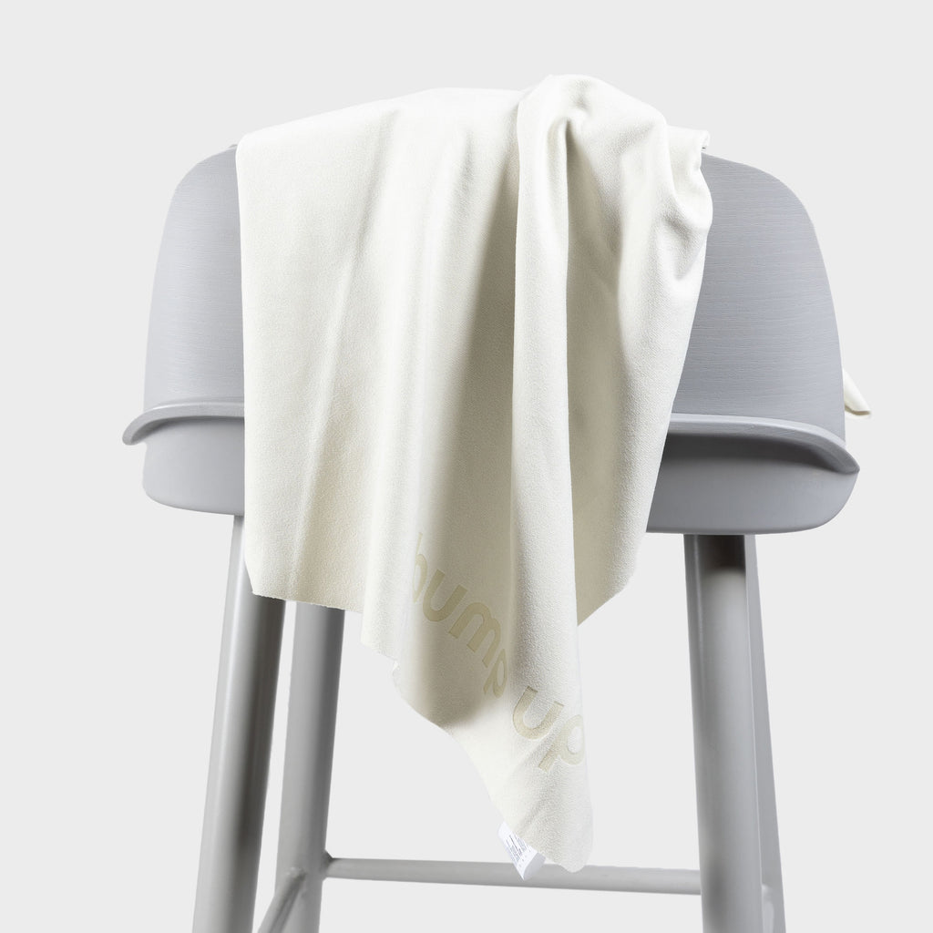 Microfiber dog towel draped over a stool demonstrating fabric weight, drape, and quick-dry structure