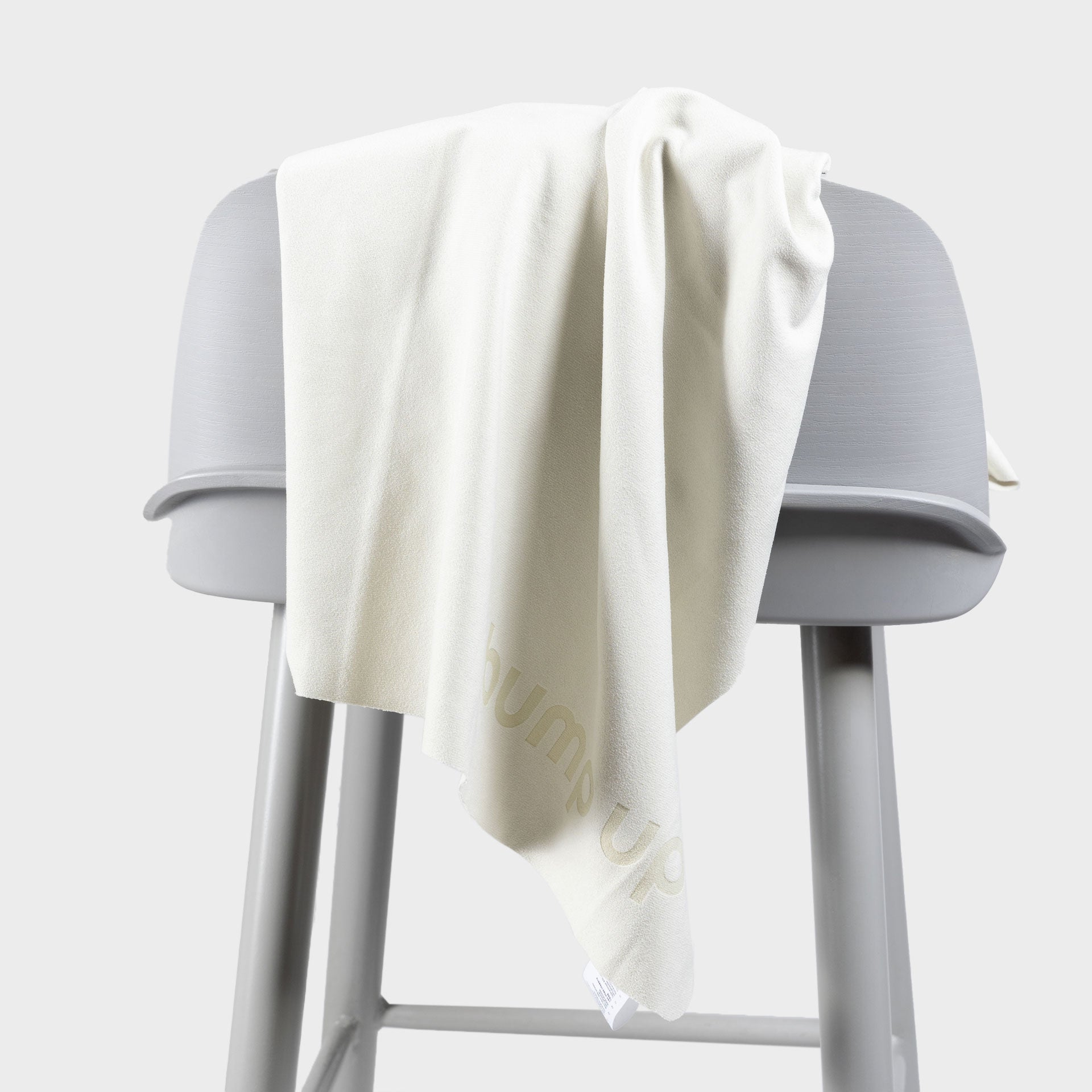 Microfiber dog towel draped over a stool demonstrating fabric weight, drape, and quick-dry structure