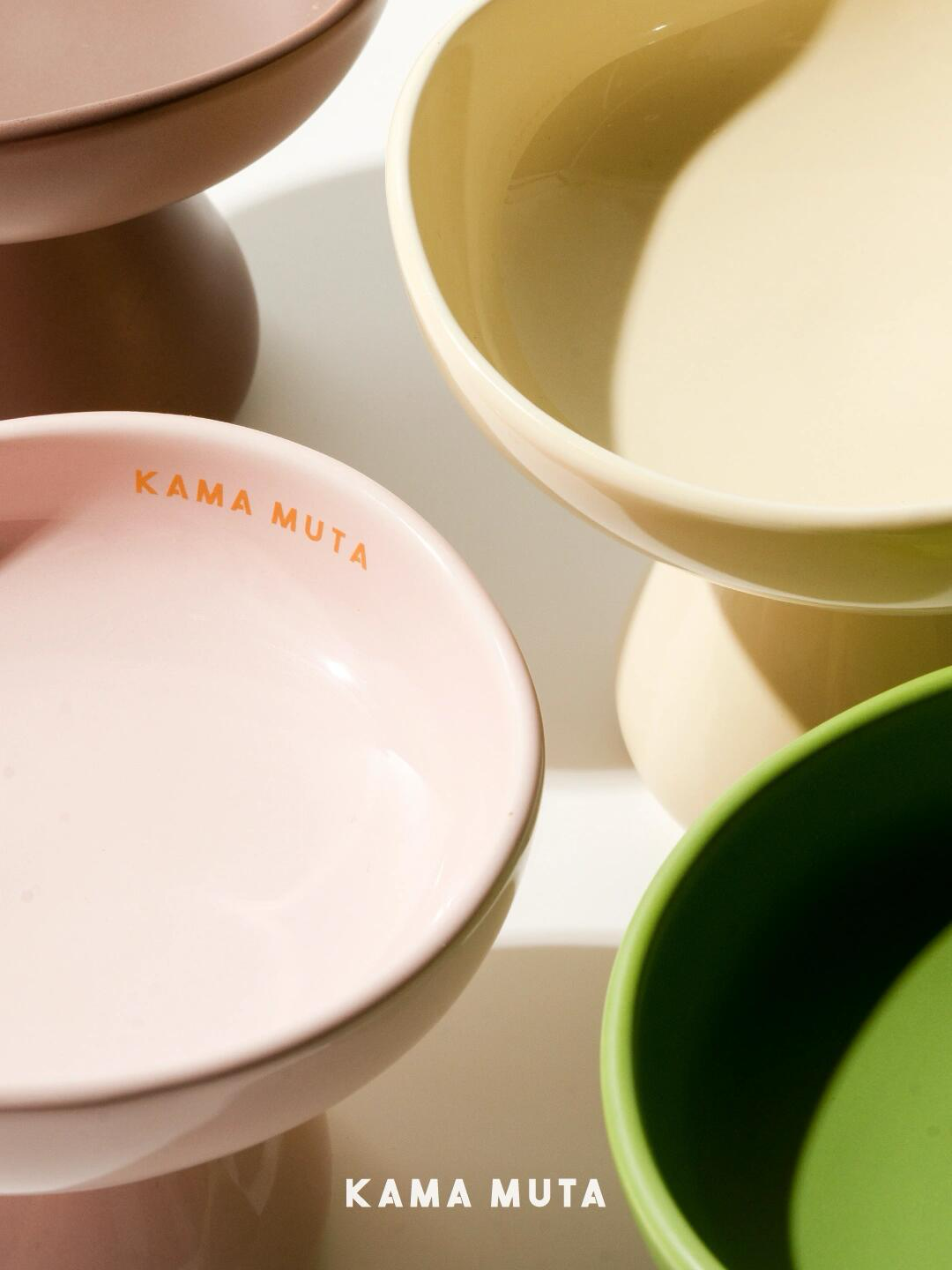 Detail view of mushroom-shape elevated ceramic cat bowls in multiple soft colors with smooth glazed surfaces.