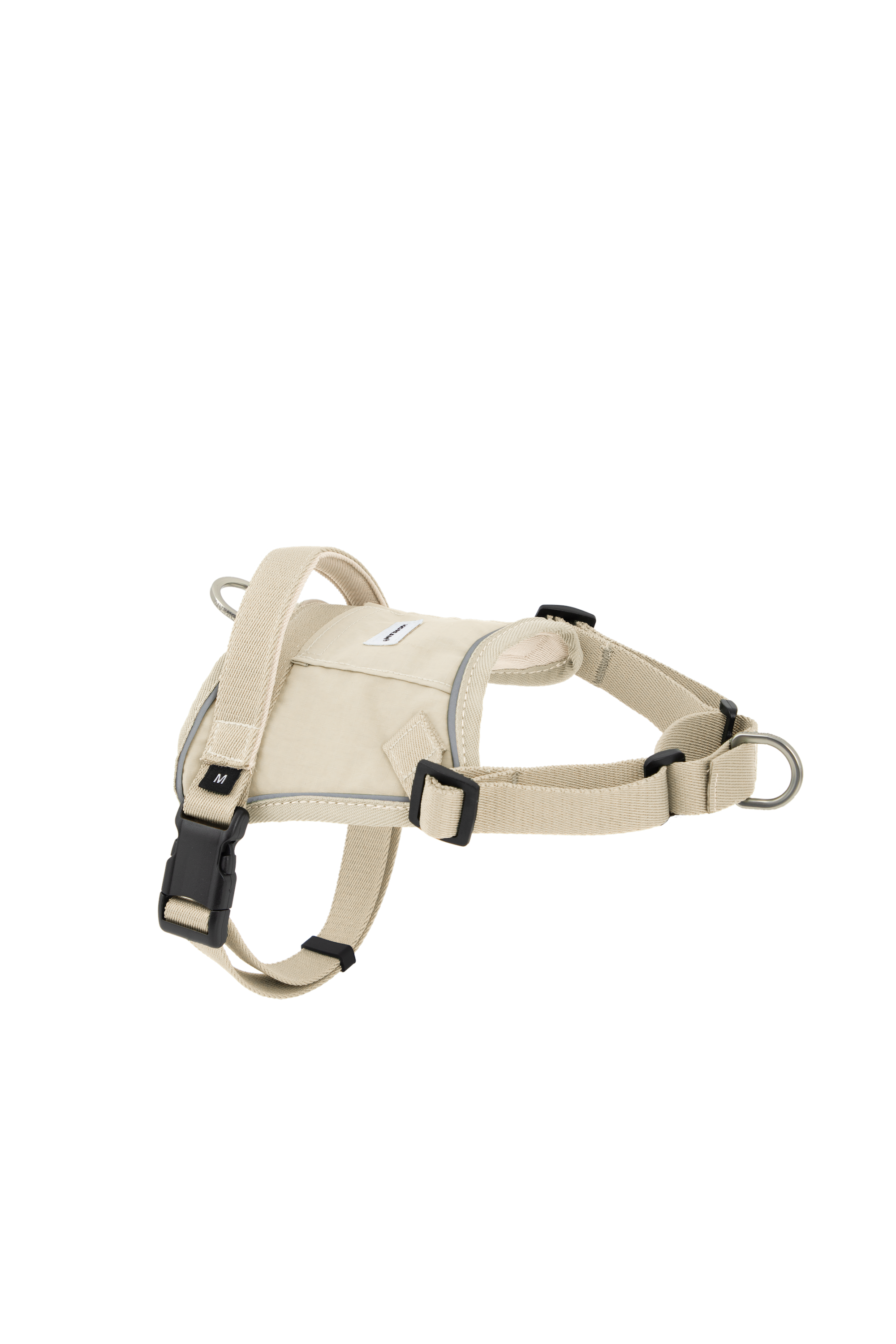 Flat lay of a beige no-pull dog harness with adjustable straps, quick-release buckle, and metal rings for front and back leash attachment.

