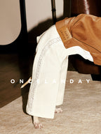 Close-up of ONCELANDAY lace dog pants on an Italian Greyhound, highlighting the breathable lace panel along the leg, textured fabric, and branded leather label at the waist.