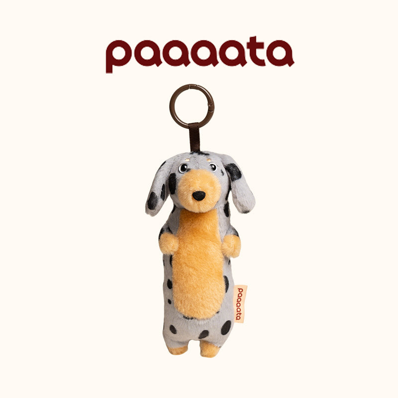 Plush dog toy with black spots and a brown tag on a white background, featuring the brand 'paaaata'.